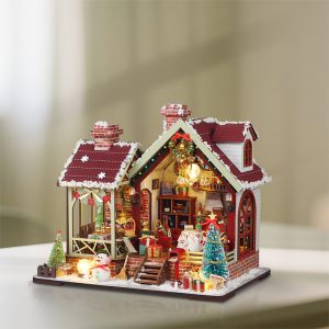 Christmas Music Box Cottage miniature with snowy roof, glowing windows and Christmas tree